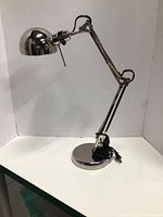 Full view of chrome adjustable desk lamp on table