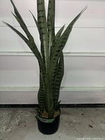 Full view of artificial snake plant showing overall height and pot
