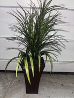 Full view of artificial tropical plant in planter