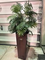 Full view of artificial fern in tall metal pot