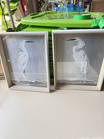 Both framed heron art pieces front view