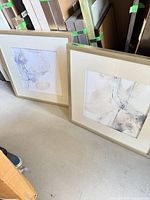 Both framed prints leaning side by side