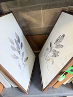 Both framed prints leaning side by side, showing walnut frames and botanical imagery