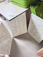 Three white framed prints leaning together