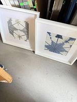 Both white square frames leaning against wall showing sizes and overall condition