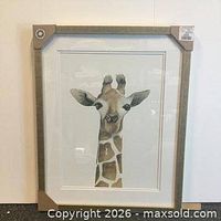 Framed giraffe print with cardboard corner protectors on white backdrop