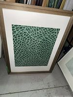 Framed succulent wallpaper art leaning against wall showing full front view