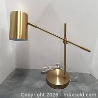 Full view of lamp showing base, adjustable arm and cylindrical shade