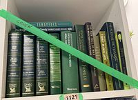 Shelf section with thirteen green-spined hardcovers