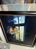 Full view of framed canvas art leaning against shelving