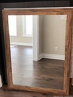 Front view of rectangular mirror showing wood frame and reflective glass