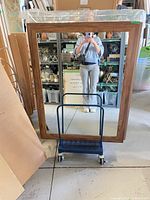 Front view showing full rectangular mirror and wood frame