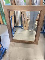 Full view of rectangular mirror showing bronzed leather-look frame and glass