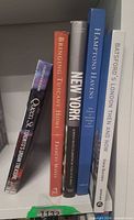 Spine view of five hardcover books standing on shelf