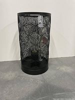 Front view of one black metal laser-cut cylindrical lamp