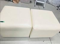 Pair of off-white cube ottomans side by side