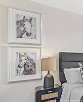 Pair of framed horse prints hung on wall above bedside table