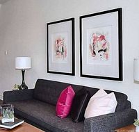 Both framed abstract prints displayed above sofa