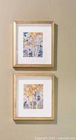 Two framed birch forest prints hung vertically on wall