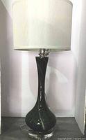 Full view of one lamp showing glass base and shade