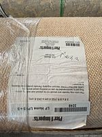Label on rolled rug showing size 8 ft x 5 ft