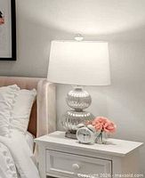 Lamp on bedside table showing shade, body, finial