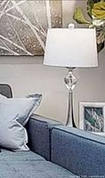 Lamp displayed in furnished setting showing shade and glass accent