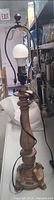 Full view of the wooden table lamp with bulb, wiring, and partial view of white shade