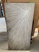 Full view of rectangular starburst canvas artwork standing upright