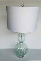 Front view of glass lamp with white shade