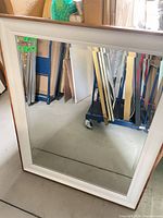 Full view of mirror showing white frame and wood edges