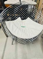 Front angle showing chrome wire construction and cushion