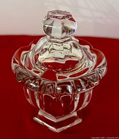 Overall view of Baccarat crystal jar with matching lid, showing faceted knob, scalloped rim and pedestal base