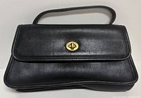 Front view of black leather handbag with gold-tone turn-lock