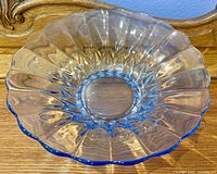 overhead view of large transparent blue glass serving bowl with scalloped edge and starburst base pattern