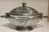 Full view of pewter soup tureen showing lid, handles, footed base and ornate detailing