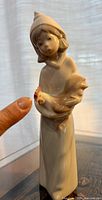 Full view of porcelain shepherdess holding rooster