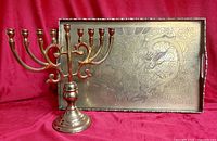 Brass nine-branch candelabra and etched rectangular tray with handles and feet displayed together
