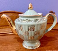 Mint green Hall teapot with lid showing gold gilt decoration, spout, handle and finial