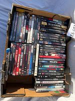 Full view of cardboard box holding two rows of DVD cases