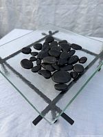 square glass platform with stones displayed