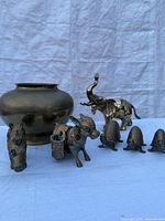 Group shot showing all brass pieces: vase, elephant, donkey, horse head, three armadillos