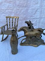 All three brass items: Coca-Cola bottle, horses sculpture, and rocking chair