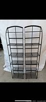 Front view of pair of identical metal grid media stands