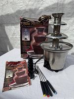 Fountain, box, booklet, fork rack and four forks overview