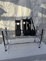 Front view of chrome two-tier shoe rack with four black and one clear plastic file holders