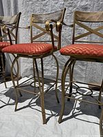 Front view of two gold painted bar stools with cushions attached