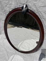 Front view of oval mirror with wooden frame