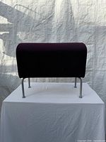 Front view showing full purple upholstered top and four gray metal legs