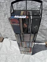 Full view of tall black wire DVD tower filled with DVDs